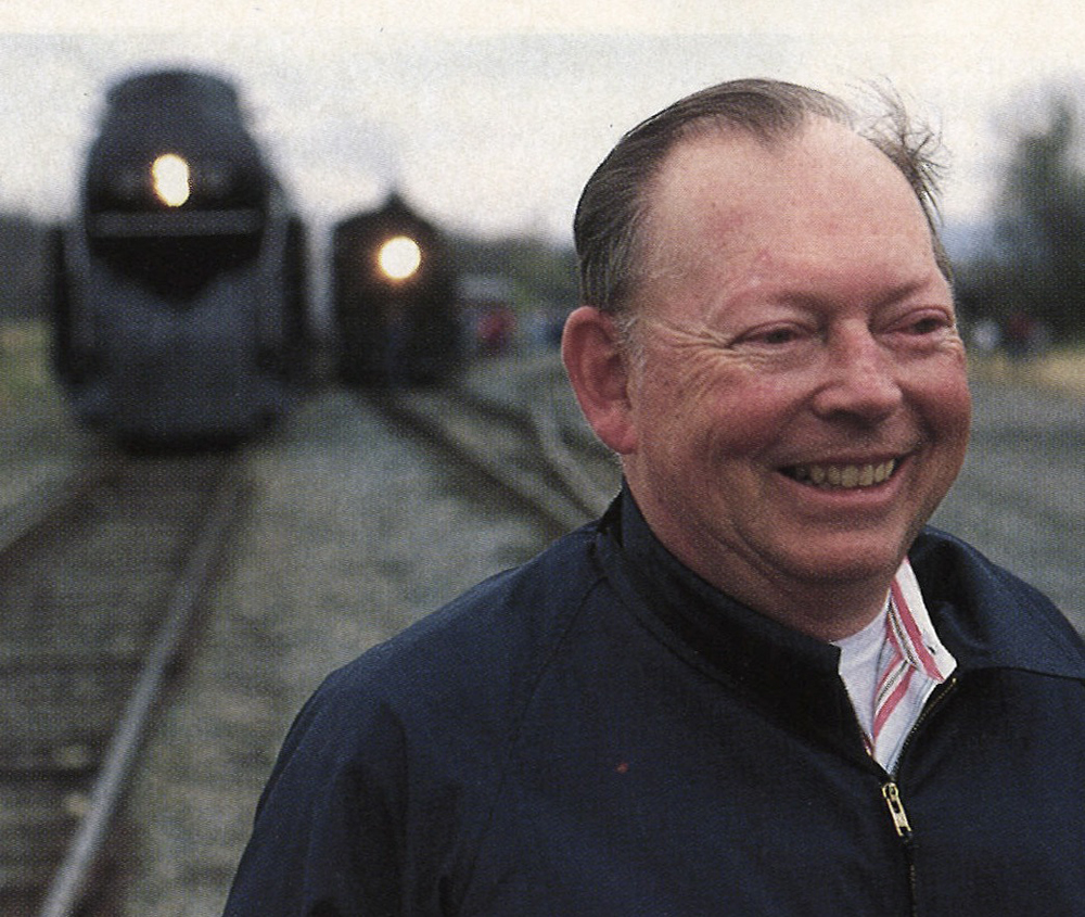 Man with steam locomotive in background