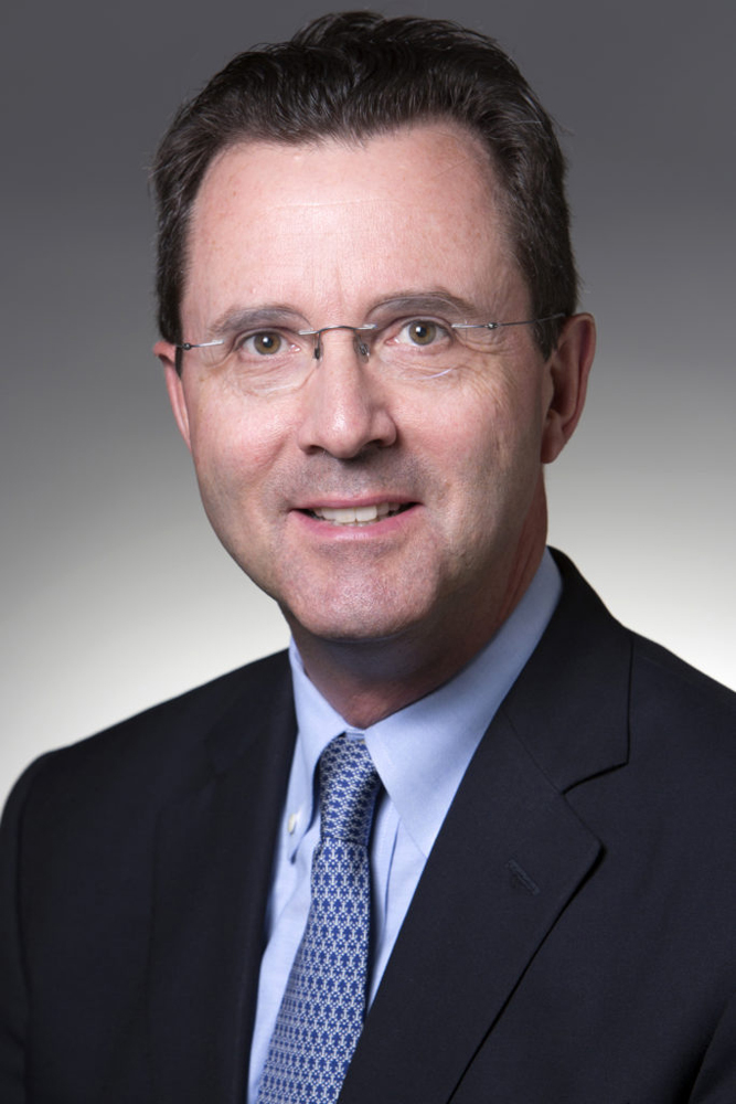 Head shot of man with black hair in black coat and tie