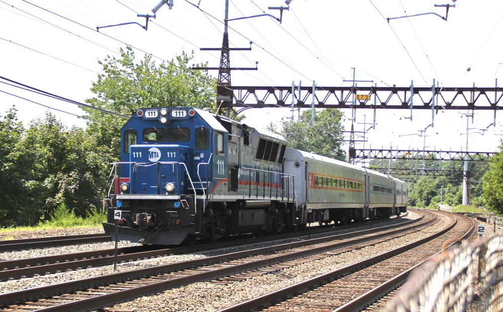 Commuter train with diesel locomotive on electrified line