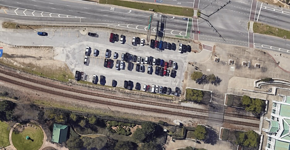 Aerial view of parking lot next to railroad tracks