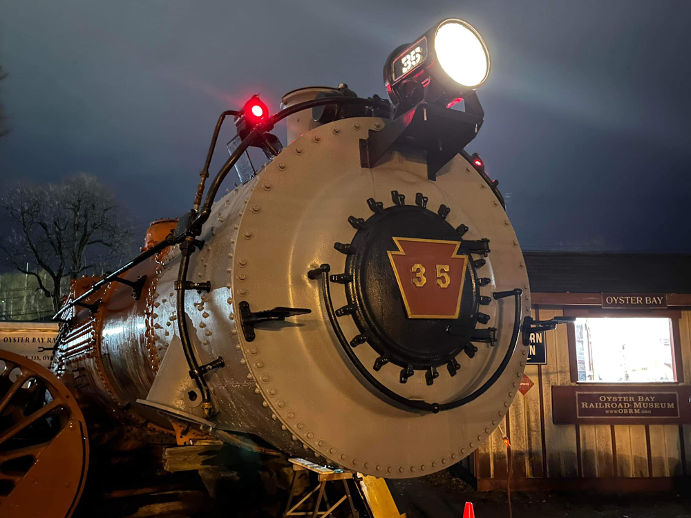 Front of steam locomotive with headlight illuminated