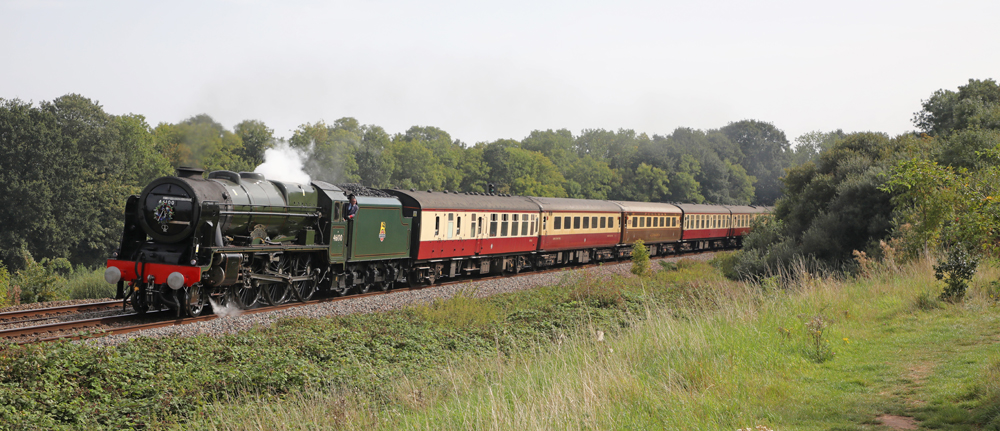 British steam locomotive with train on broad curve