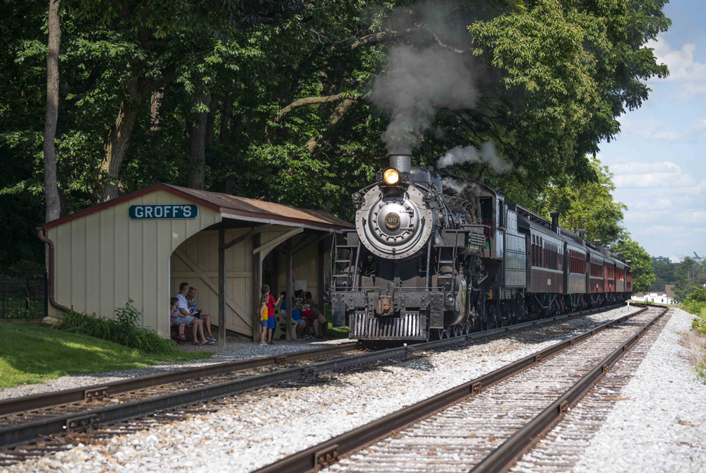 Steam locomotive at small shelter-type station