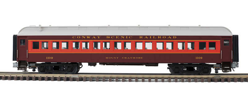 Color photo of O gauge passenger car painted red, orange, and silver.