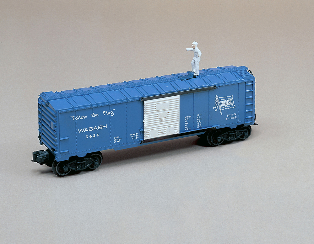 blue and white boxcar with figure on top