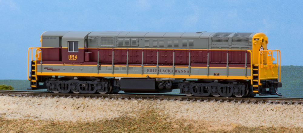 Color photo of N scale locomotive painted gray, maroon, and yellow.