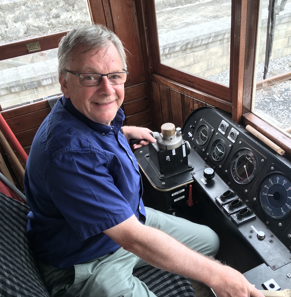 Individual sitting in the cab of a locomotive 