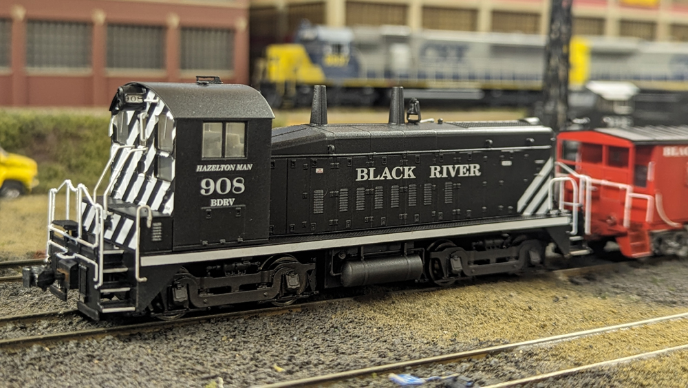 Color photo of black-and-silver switcher on HO scale layout.