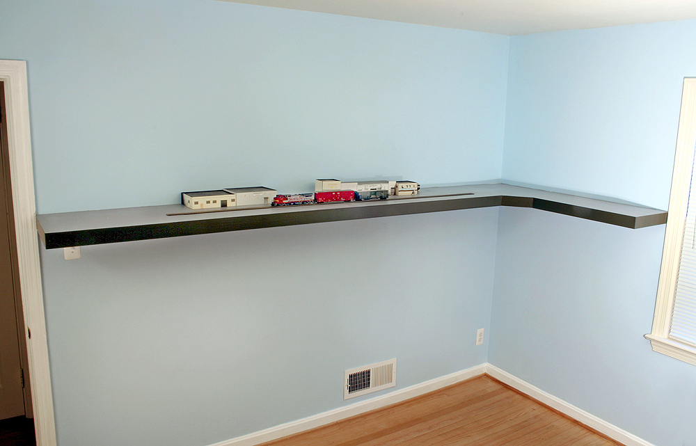 An L-shaped layout is attached to a blue wall with no visible supports