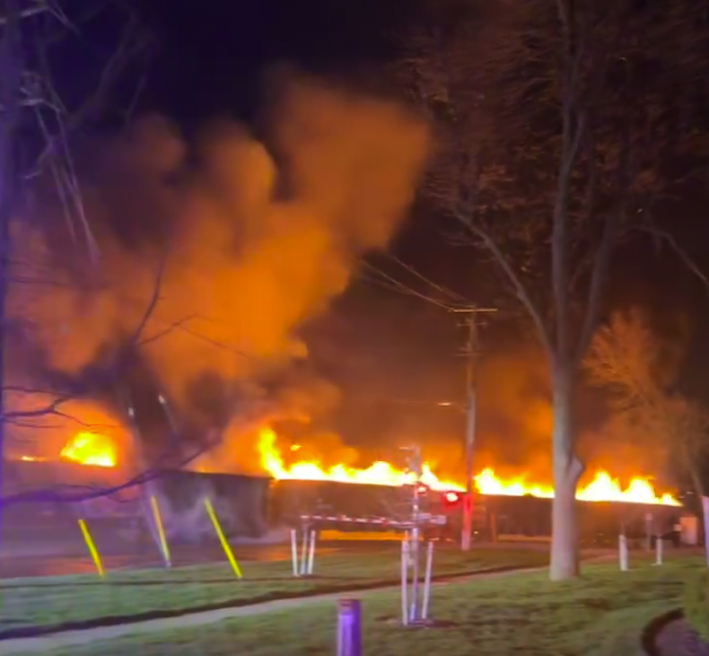 Night scene with five gondola cars on fire.