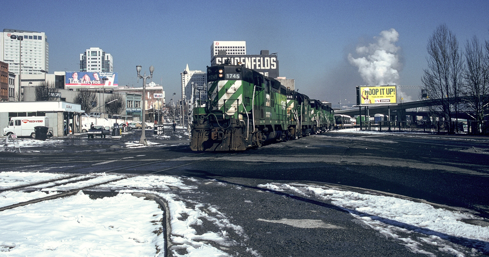 green and white locomotive with snow on ground