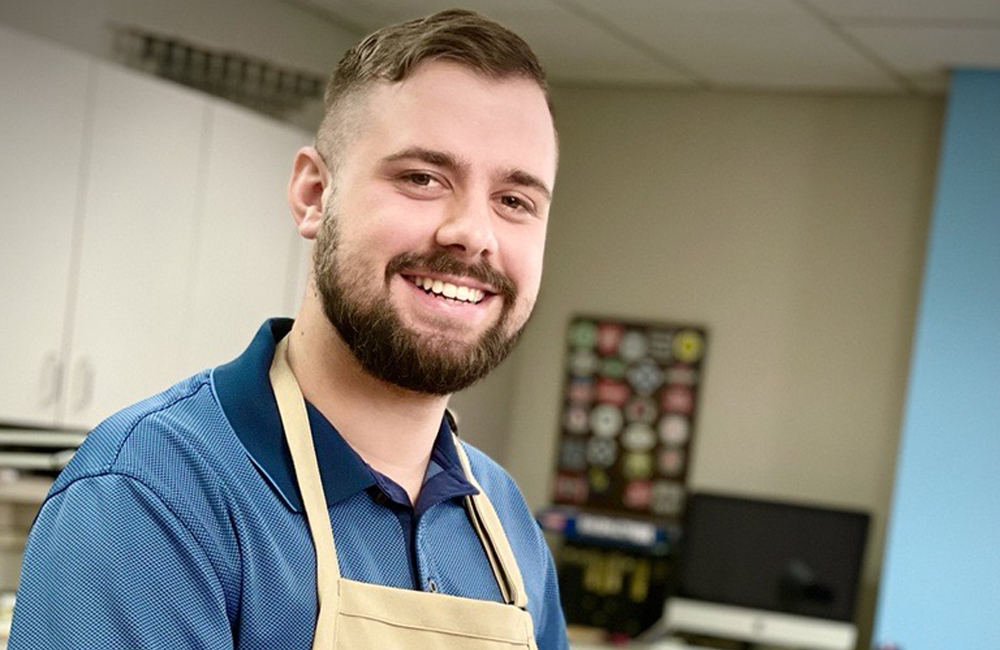 An image of a man in a blue polo shirt standing in the Model Railroader workshop