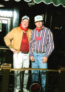 Two men stand on the end platform of an observation car