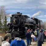 Steam locomotive surrounded by people