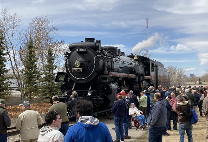 Steam locomotive surrounded by people