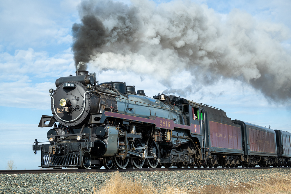 Three-quarter shot of 4-6-4 steam locomotive with maroon trim and tender