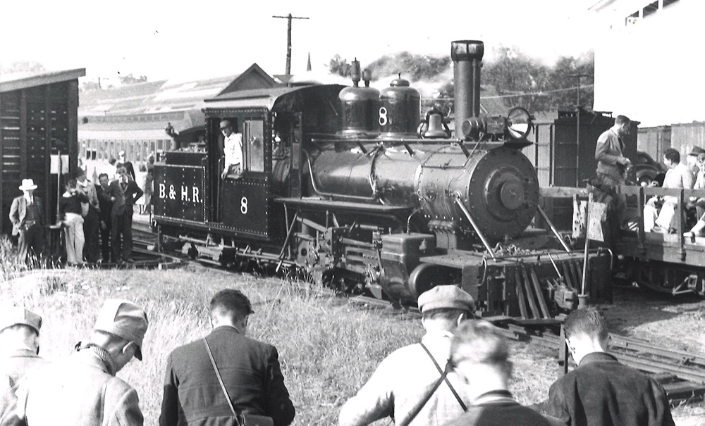 Small steam locomotive surrounded by people