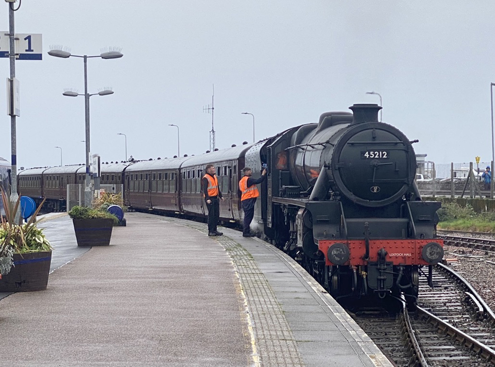 British train with steam locomotive at station.