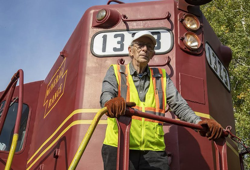 Man in safety vest on front of locomotive