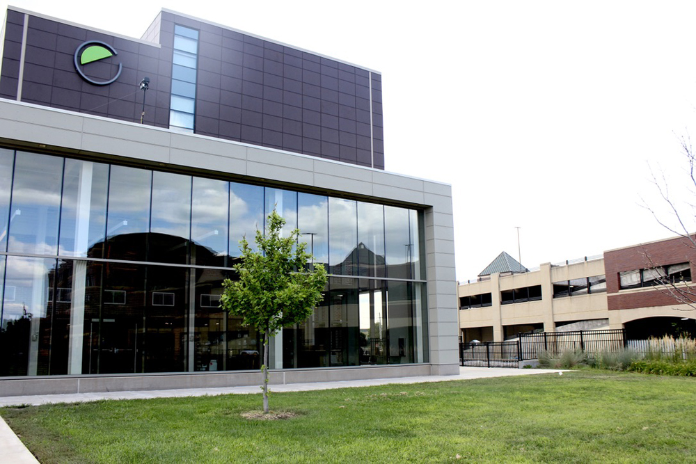 Modern glass-walled building next to parking garage