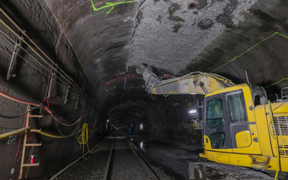 Yellow construction equipment inside railroad tunnel