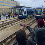 People taking pictures of light rail trains