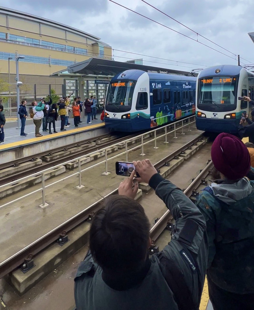 People taking pictures of light rail trains