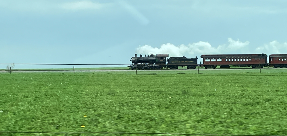 steam locomotive in distance with passenger cars