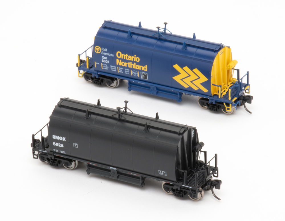 Color photo of N scale hoppers painted in blue-and-yellow and solid black paint schemes.