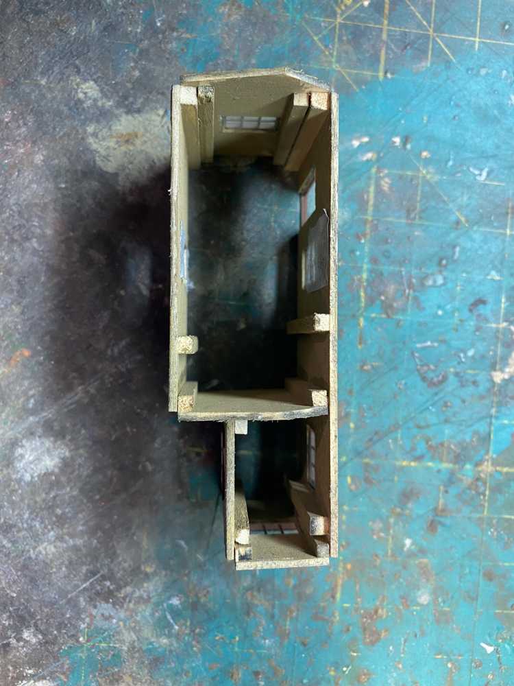 Model building looking down from above without roof showing wood bracing strips.