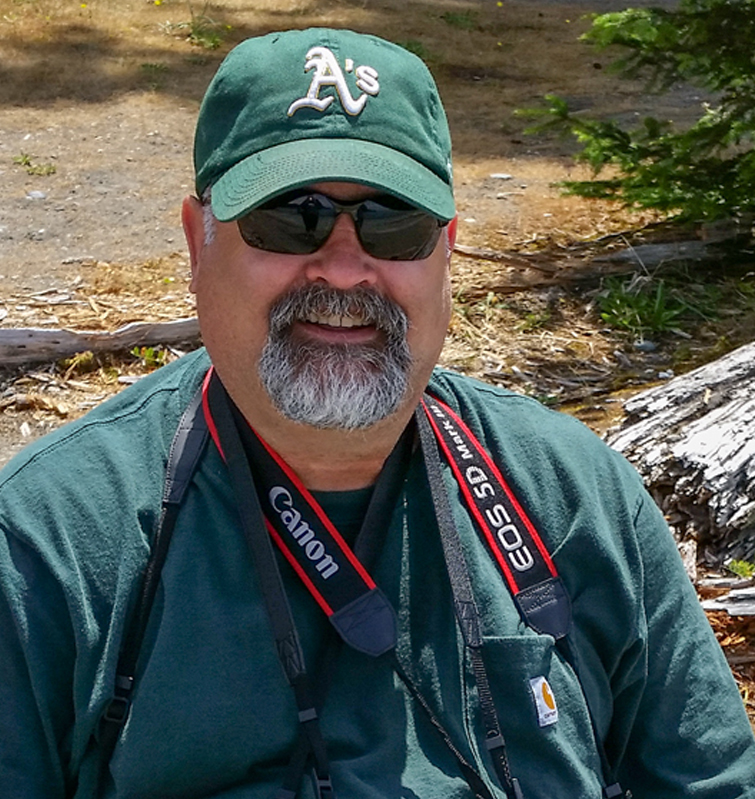 man with green shirt and cameras