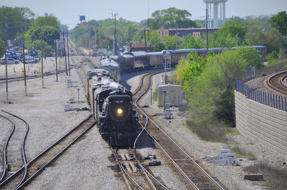 Passenger train with steam engine on curve entering yard