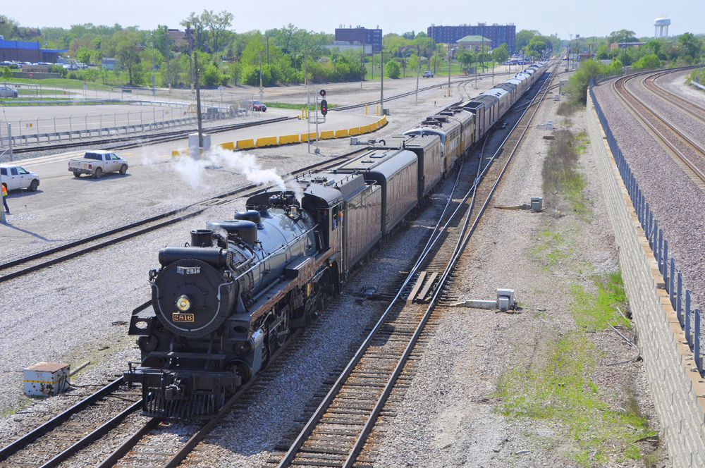 Passenger train with steam locomotive on long straight