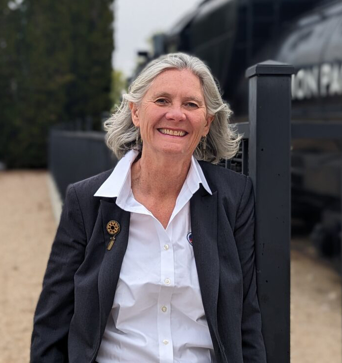 Woman standing with steam locomotive in background