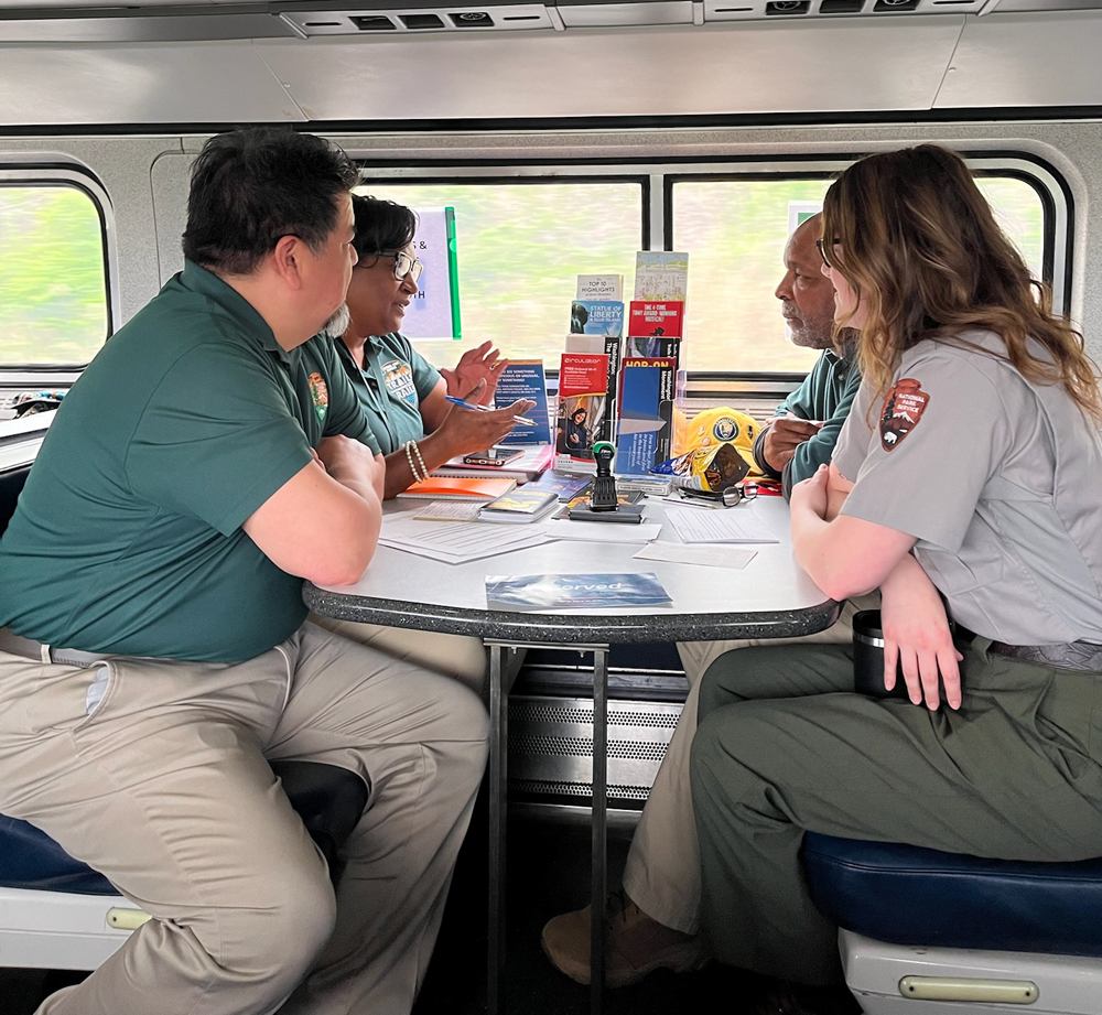 Four people at table in Amfleet car