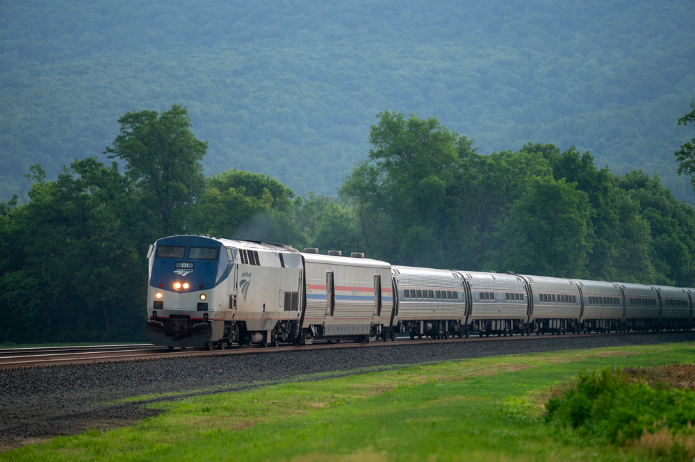 Amtrak train on track with trees in background