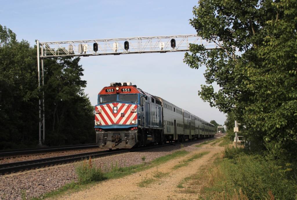Commuter train passes under signal bridge