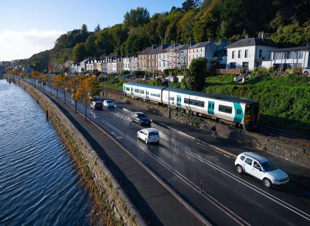 train on rail in Ireland next to water