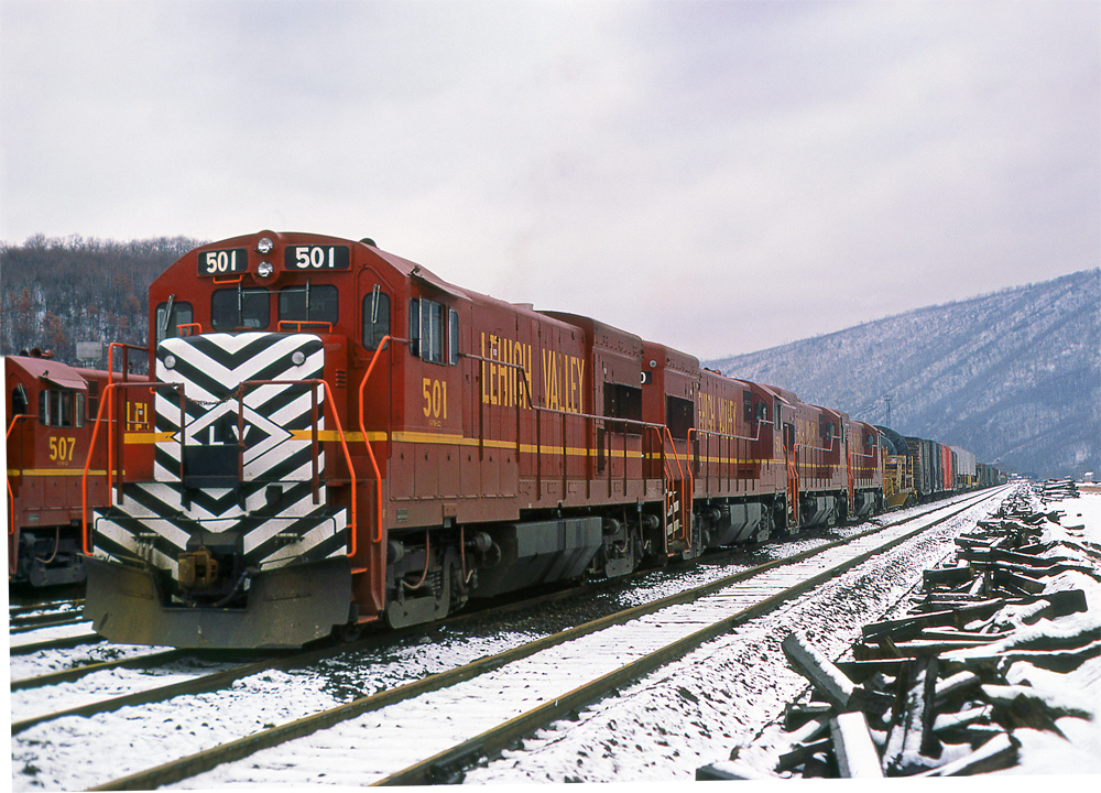 red locomotive with black and white striped nose by snow