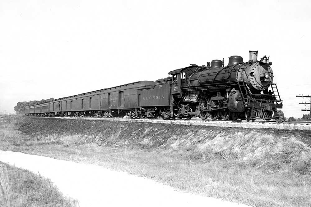 Smokeless steam locomotive with passenger train on elevated trackage