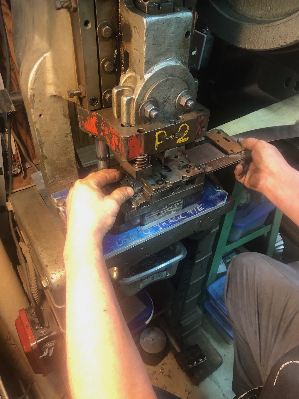 hand holding a piece of steel in a machine
