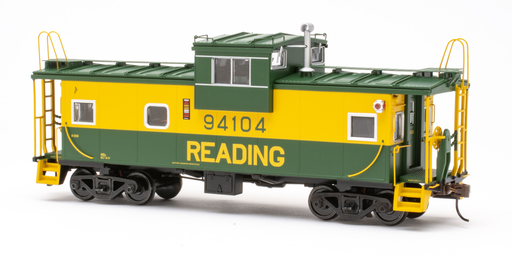 Color photo of S scale caboose painted green and yellow.