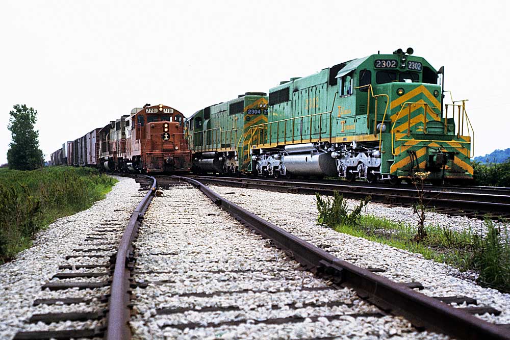 Diesel Illinois Terminal locomotives passing orange locomotives