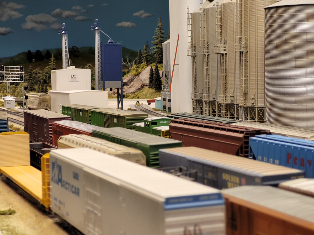The roofs of many model freight cars at an interchange yard on a model railroad layout