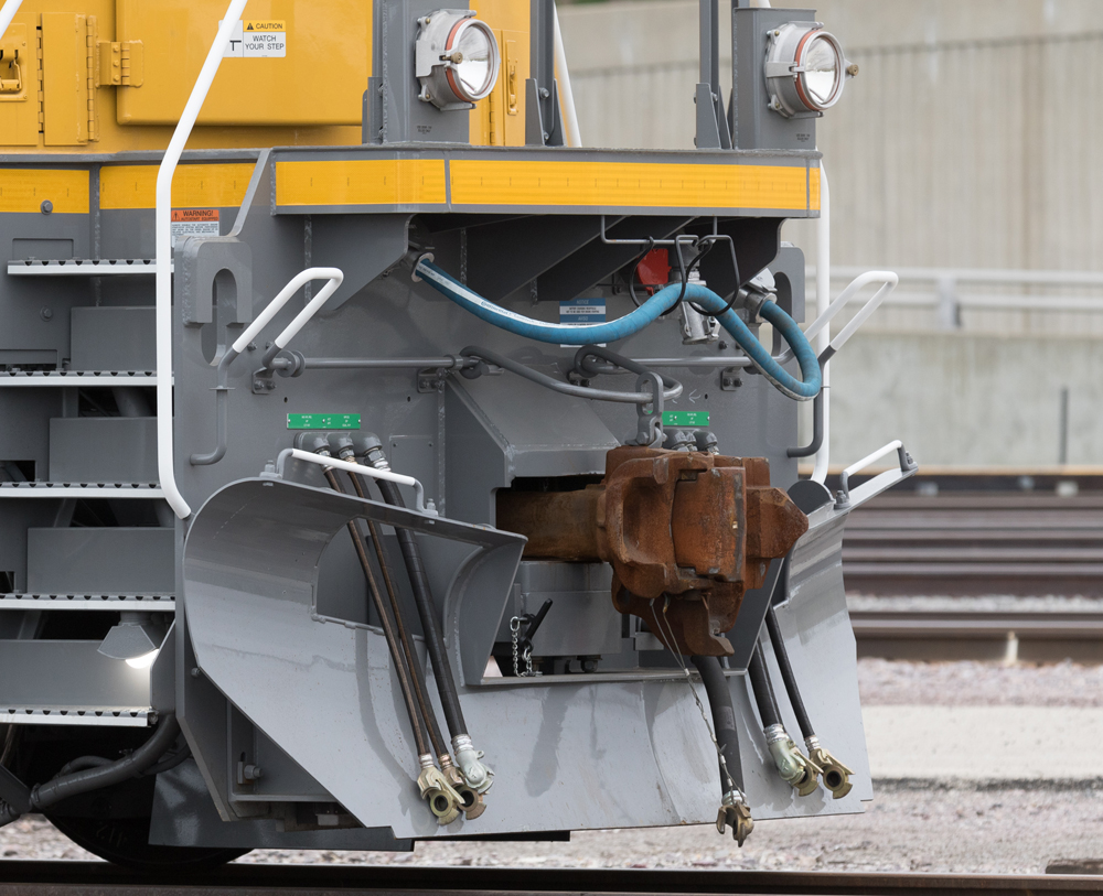 Close-up of portion of front of locomotive, showing coupler, hoses, other connections