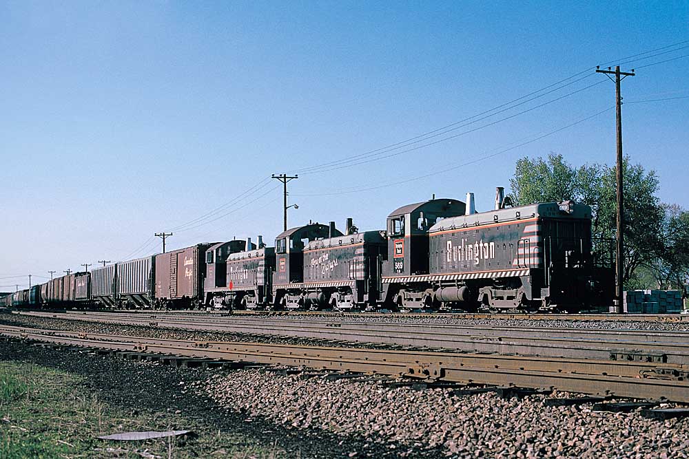 Black Burlington Route diesel locomotives with freight train on embankment