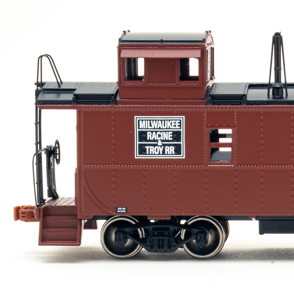 Side view of HO caboose painted brown and black.