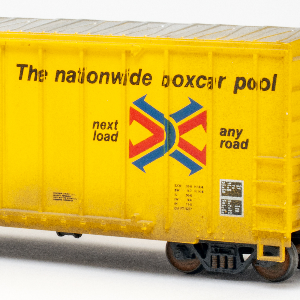 Color photo of HO scale boxcar painted yellow on white background.