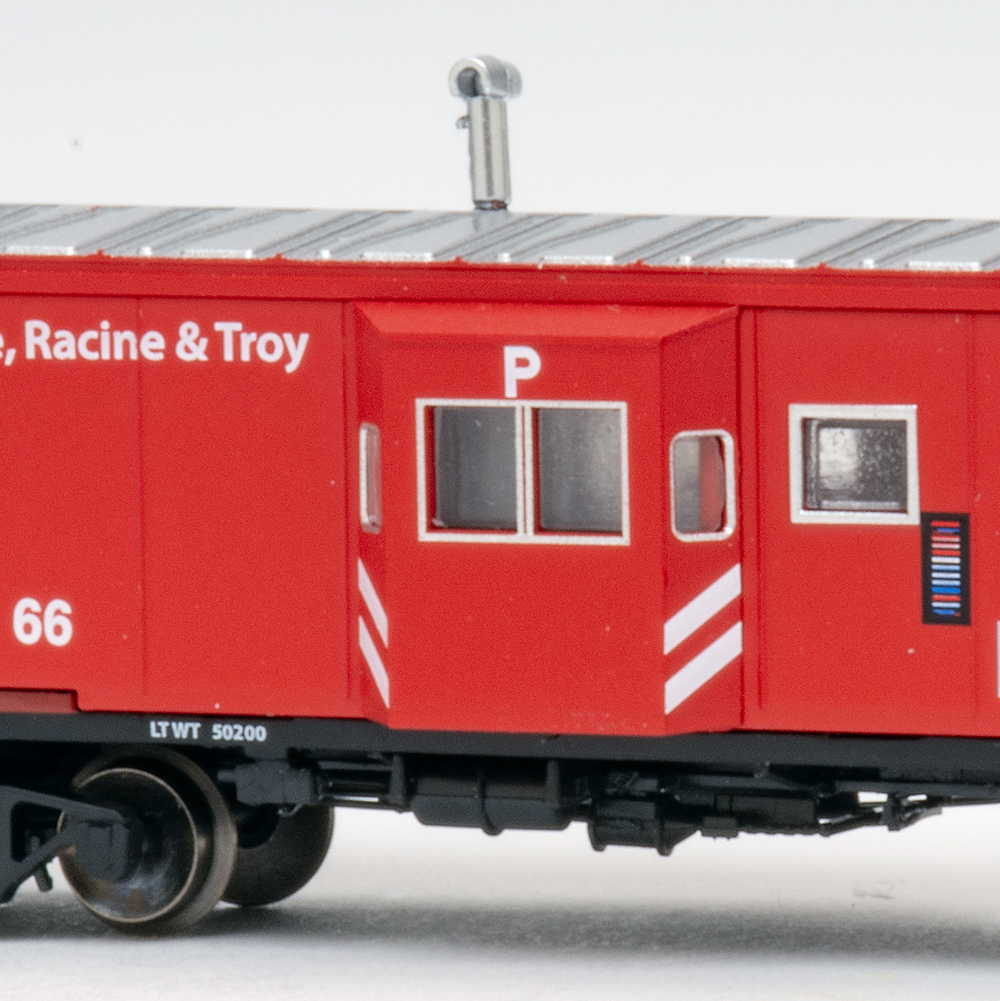 Color photo of N scale caboose painted red, black, and silver.