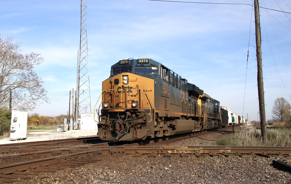 Freight train with blue locomotives crossing diamond